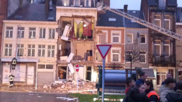 Ein Gebäude wurde durch eine Explosion beschädigt, Trümmer liegen auf der Straße.