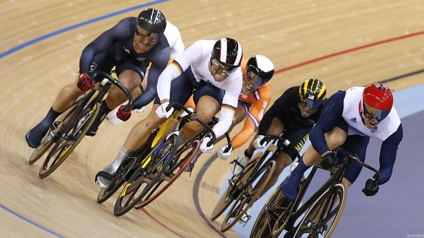 Mehrere Radrennfahrer fahren auf einer Bahn im Velodrom.