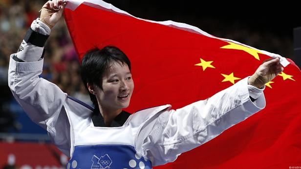Eine Taekwondo-Sportlerin feiert mit der chinesischen Flagge.