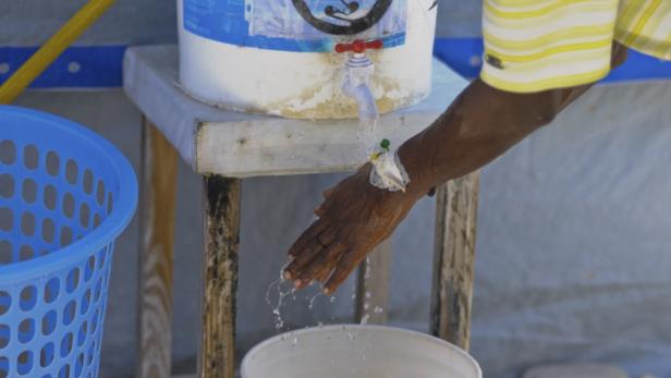 A cholera patient washes his hands at a cholera tr
