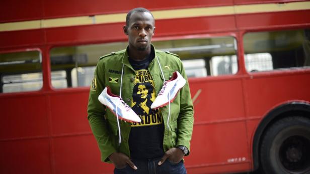 Sprinter Usain Bolt of Jamaica poses with his running spikes and official team uniform for the London 2012 Olympic Opening Ceremony during a photo shoot, arranged by his sponsors PUMA, beside a traditional routemaster bus outside the British Museum in London in this June 1, 2012 file photo. Bolt will defend the 100m and 200m gold medals he won in Beijing in this summer&#039;s Games. Over 116 years the Olympic 100 metres final has produced drama, pain, controversy, disillusionment, incredulity and unbridled joy - all crammed into a race lasting little longer than it takes to say &quot;Baron Pierre de Coubertin.&quot; REUTERS/Dylan Martinez (BRITAIN - Tags: SPORT OLYMPICS ATHLETICS)