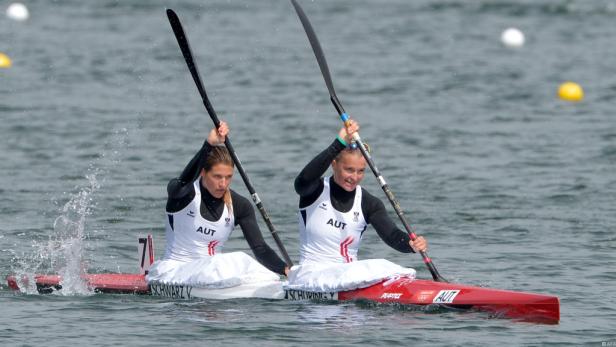 Zwei Kanutinnen des österreichischen Teams paddeln auf einem See.