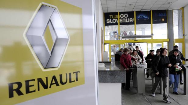 Menschen betreten ein Renault-Gebäude durch Drehkreuze.