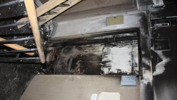 Ein Raum mit Brandschäden und Rußablagerungen an Wänden und Decke.