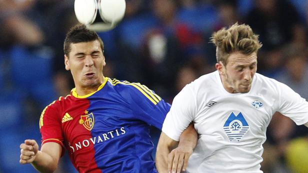 Zwei Fußballspieler kämpfen um den Ball während eines Spiels.