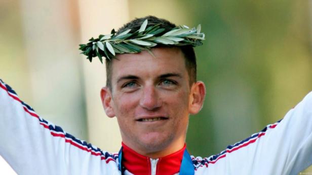 Ein Mann mit einem Lorbeerkranz auf dem Kopf und einer Medaille um den Hals.