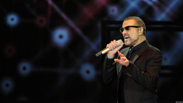 George Michael singt während eines Konzerts in ein Mikrofon.