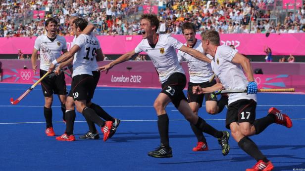 Deutsche Hockeyspieler jubeln auf dem Spielfeld bei den Olympischen Spielen 2012 in London.