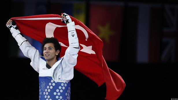 Ein Taekwondo-Kämpfer feiert mit der türkischen Flagge seinen Sieg.