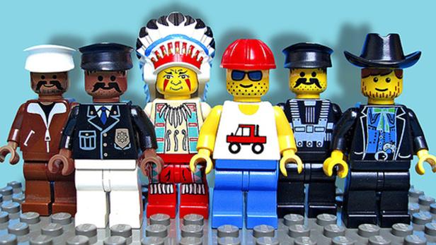 Eine Reihe von Lego-Figuren, darunter ein Polizist, ein Cowboy und ein Indianer.
