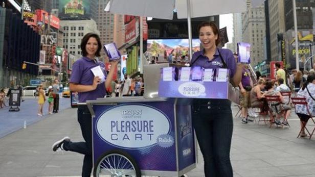 Zwei Frauen stehen mit einem „Pleasure Cart“ von Trojan in New York City.