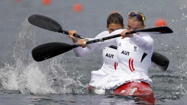 Zwei österreichische Kanutinnen paddeln in einem roten Kanu auf dem Wasser.