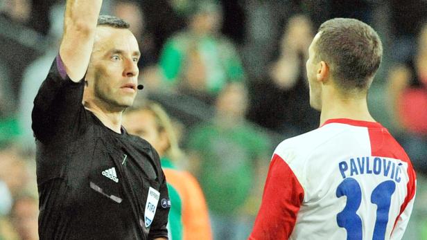 Ein Schiedsrichter zeigt einem Spieler die gelbe Karte.