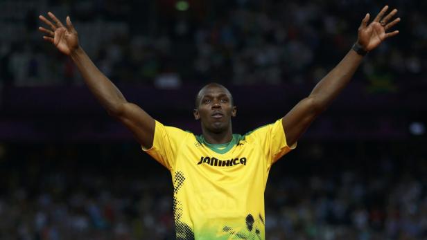 Usain Bolt jubelt mit erhobenen Armen in seinem jamaikanischen Nationaltrikot.