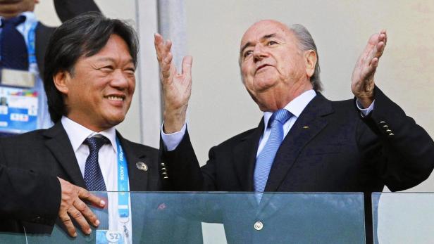 Sepp Blatter und ein weiterer Mann schauen bei einem Fußballspiel zu.