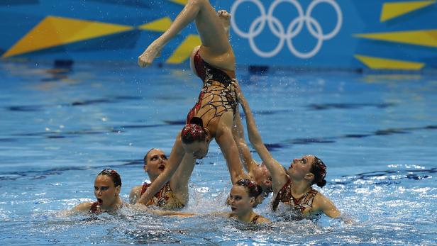 Eine Gruppe Synchronschwimmerinnen formt eine Pyramide im Wasser.