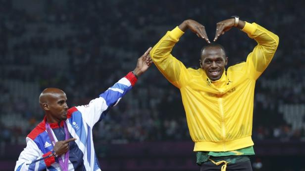 Usain Bolt formt ein Herz mit seinen Händen, während Mo Farah auf ihn zeigt.