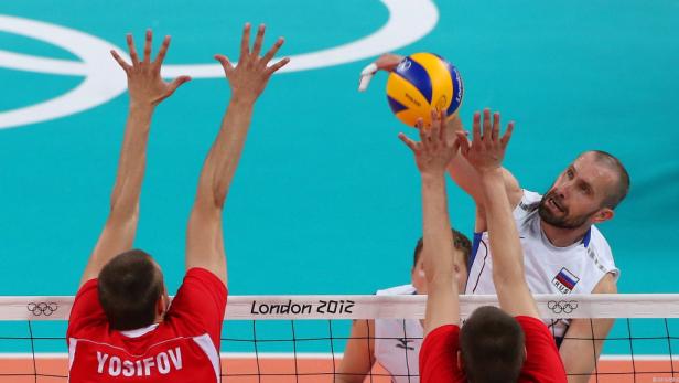Ein Volleyballspieler schlägt den Ball über das Netz während eines Spiels.