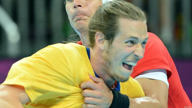 Zwei Handballspieler kämpfen um den Ball.