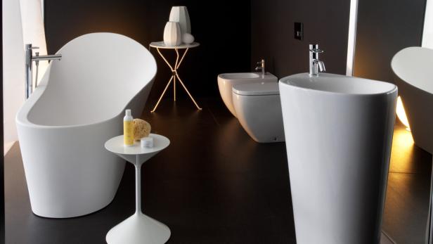 Ein modernes Badezimmer mit freistehender Badewanne, Waschtisch und Bidet in Weiß.