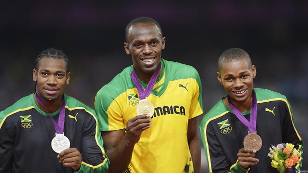 Usain Bolt mit seinen jamaikanischen Teamkollegen bei einer Siegerehrung mit Medaillen.