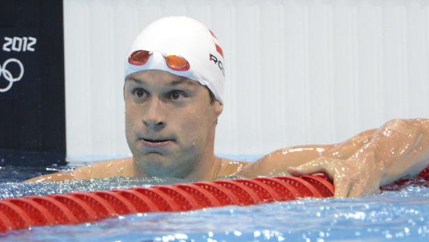 Ein Schwimmer mit Badekappe und Schwimmbrille im Schwimmbecken.
