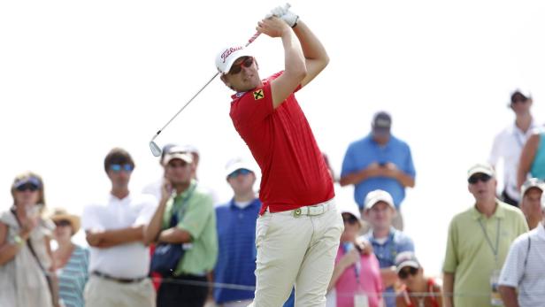 Ein Golfspieler schwingt seinen Schläger vor einer Zuschauermenge.