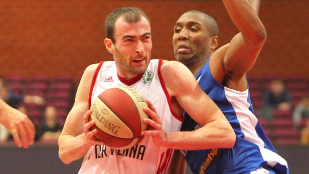 Zwei Basketballspieler kämpfen um den Ball während eines Spiels.