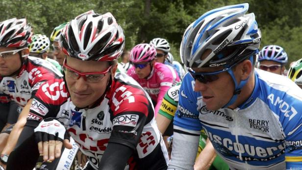 Radrennfahrer während eines Rennens mit Helmen und Sportbekleidung.