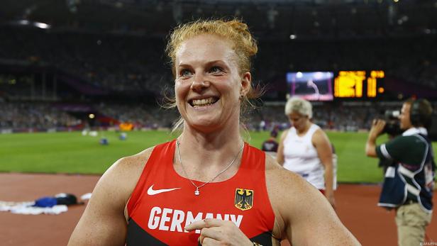 Eine deutsche Athletin lächelt auf einer Leichtathletikbahn.