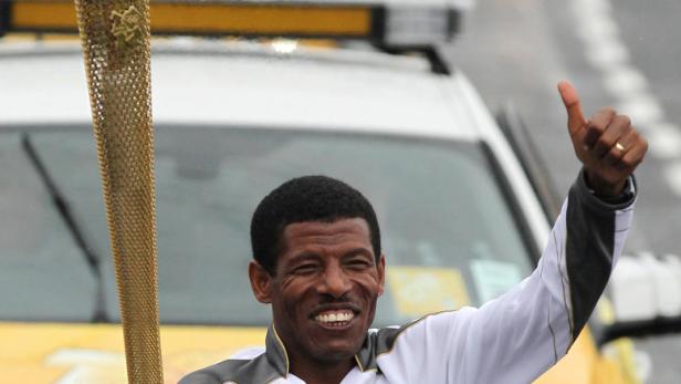 Haile Gebrselassie trägt die olympische Fackel für London 2012.