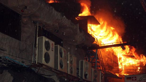Ein Gebäude steht in Flammen, mit mehreren Klimaanlagen an der Fassade.