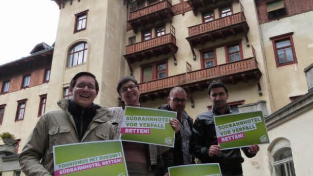 Eine Gruppe von Menschen demonstriert vor dem Südbahnhotel mit Schildern, um es zu retten.