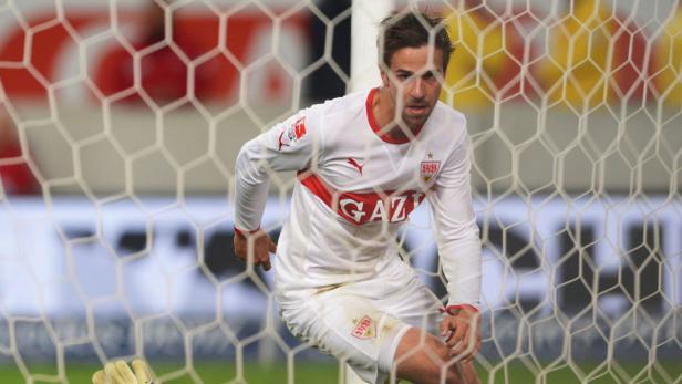 Ein Fußballspieler des VfB Stuttgart steht hinter einem Tornetz.