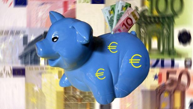 Ein blaues Sparschwein mit Euro-Symbolen und Geldscheinen vor einem verschwommenen Hintergrund aus Banknoten.
