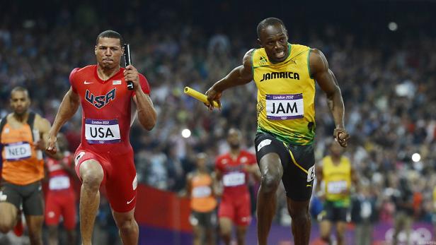 Usain Bolt übergibt den Staffelstab bei einem Staffellauf an seinen Teamkollegen.