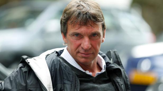 Ein Mann mit braunen Haaren und einer schwarzen Jacke blickt in die Kamera.