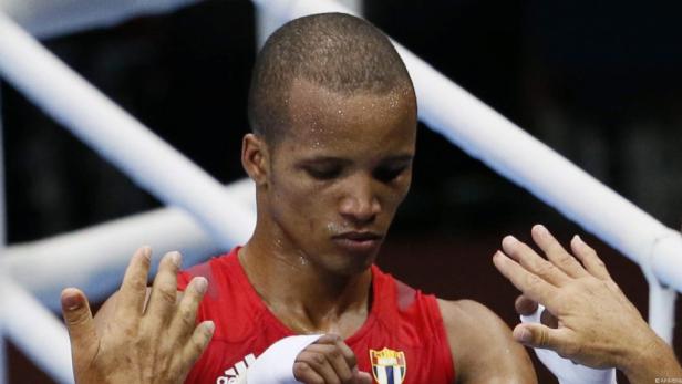 Ein Boxer mit Schweiß auf der Stirn steht im Ring.
