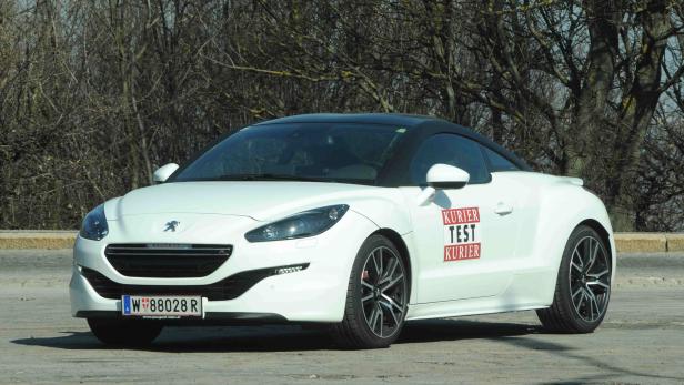 Ein weißer Peugeot RCZ mit schwarzem Dach steht im Freien.
