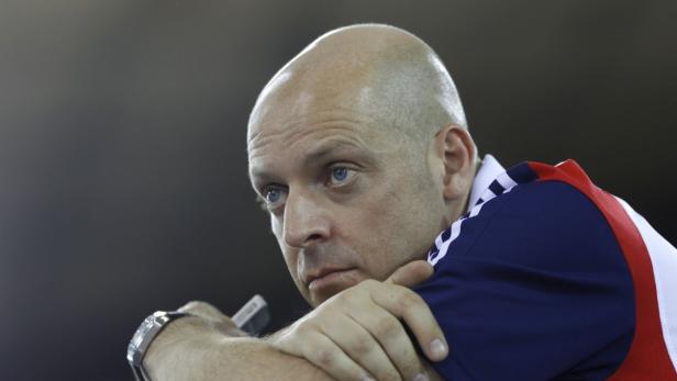 Ein Mann mit blauem Hemd und Armbanduhr blickt nachdenklich zur Seite.