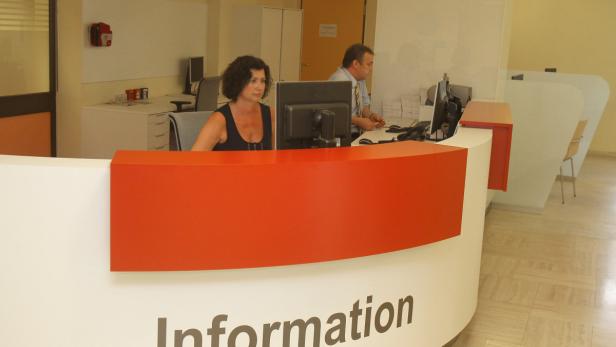 Zwei Angestellte arbeiten an einem Informationsschalter.