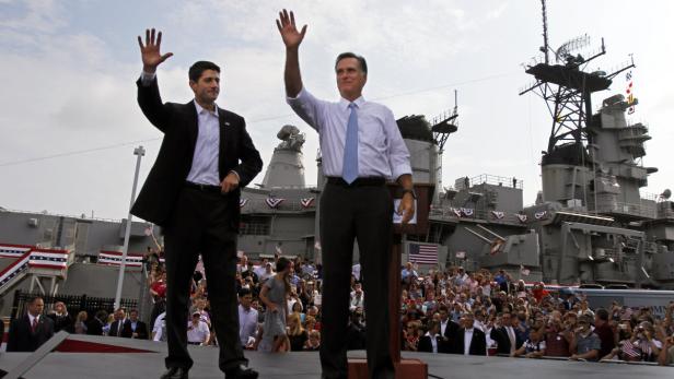 Mitt Romney und Paul Ryan winken vor einer Menschenmenge und dem Schlachtschiff USS Wisconsin.
