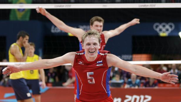 Ein russischer Volleyballspieler jubelt mit ausgestreckten Armen während eines Spiels.