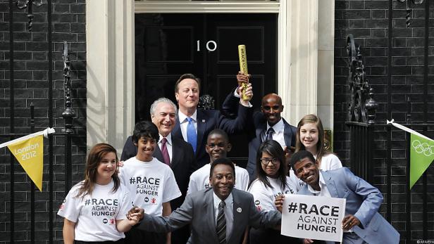 Eine Gruppe von Personen, darunter David Cameron, Mo Farah und Pelé, vor der Downing Street 10 für „Race Against Hunger“.