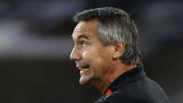 Ein Mann mit grau meliertem Haar schaut zur Seite und lächelt.