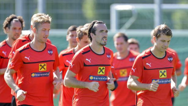 Mehrere österreichische Fußballspieler beim Training in roten Trikots.