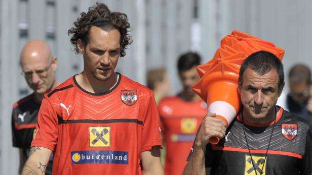 Ein Fußballspieler und ein Trainer mit Hütchen beim Training.