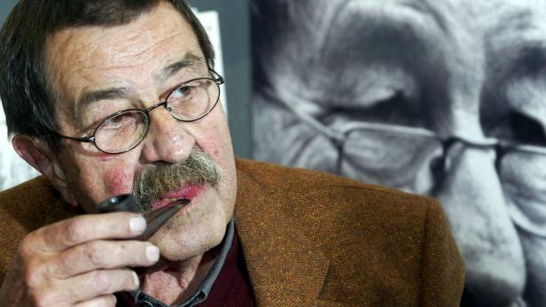 Ein älterer Mann mit Brille und Schnurrbart raucht eine Pfeife.