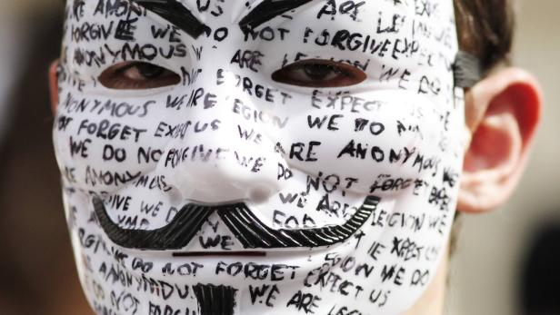 Eine Guy-Fawkes-Maske, bedeckt mit dem Schriftzug „We are Anonymous. We are Legion. We do not forgive. We do not forget. Expect us.“.