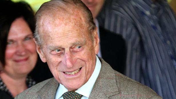 Prinz Philip lächelt in einem Tweed-Sakko mit Krawatte.